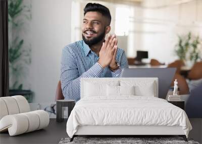 Young Asian Indian businessman working on laptop in modern office Wall mural